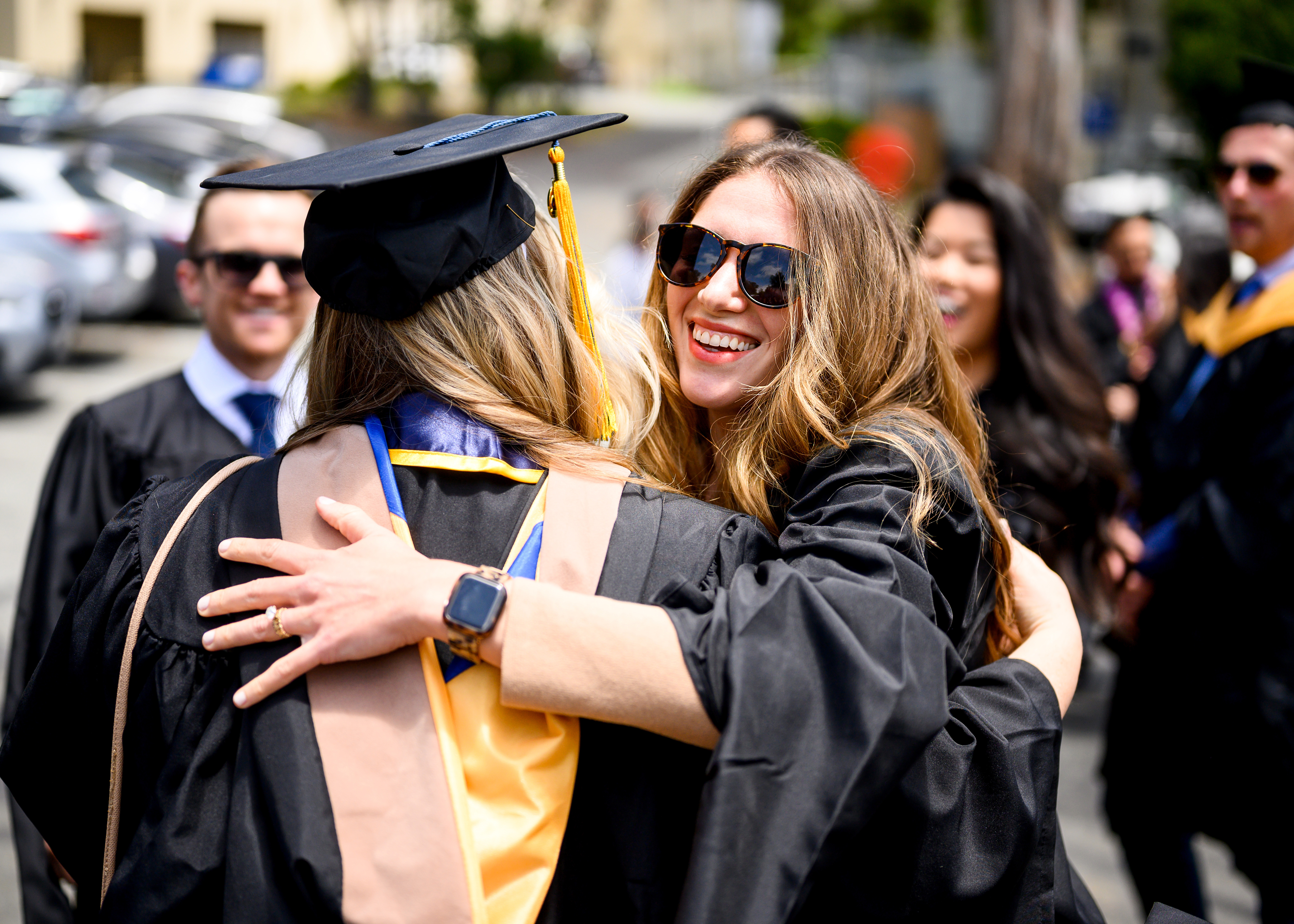 Two students hug at graduation