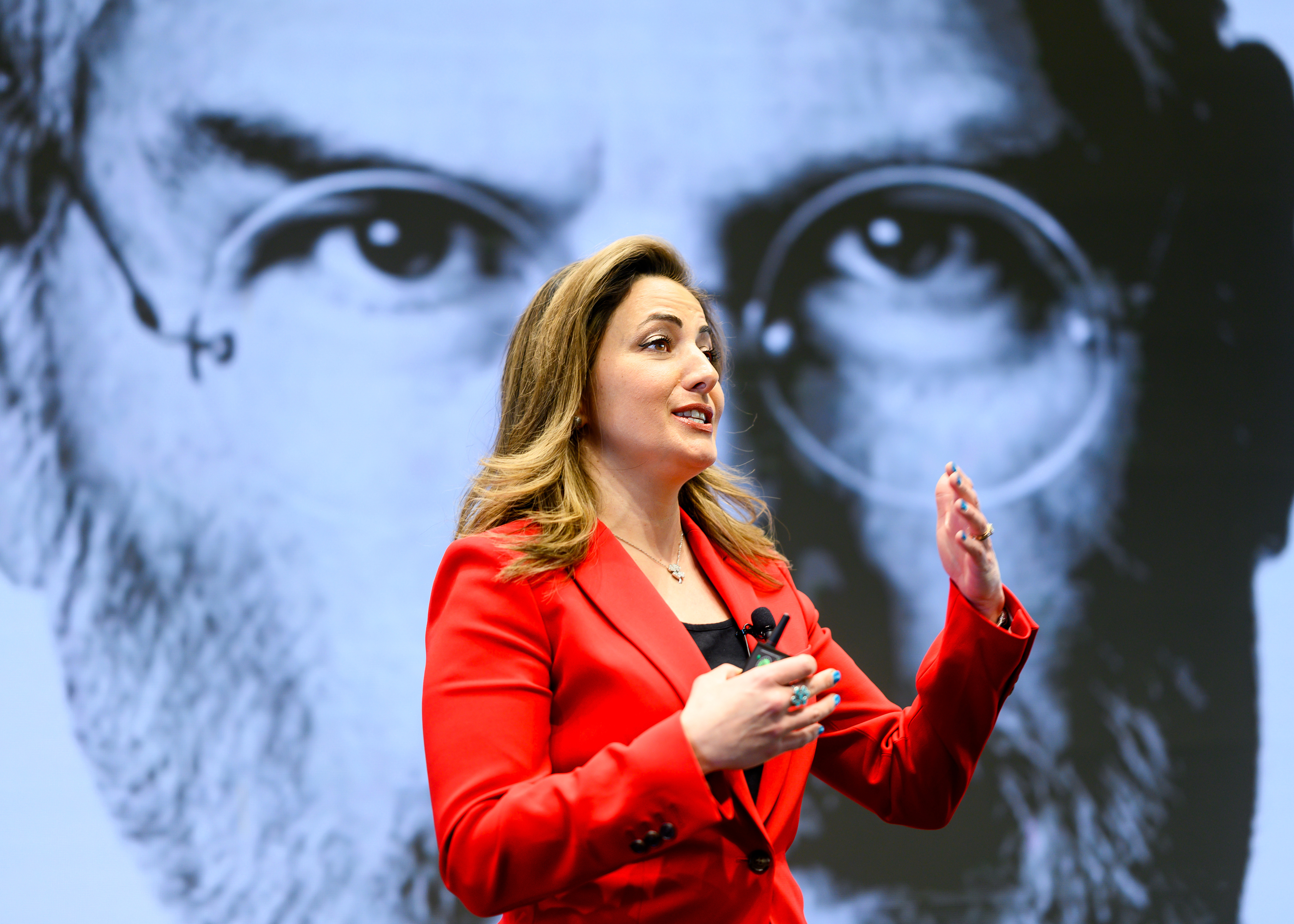 A female professor lectures in front of a picture of Steve Jobs