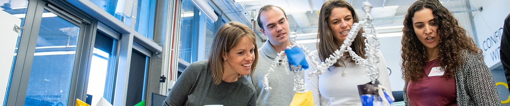 Four students looking at an experiment