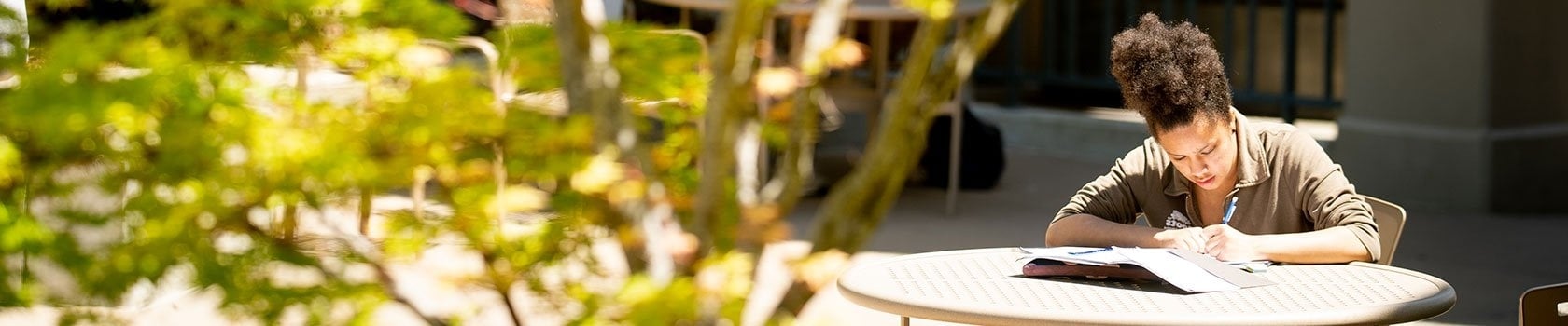 A woman writing in a notebook outside